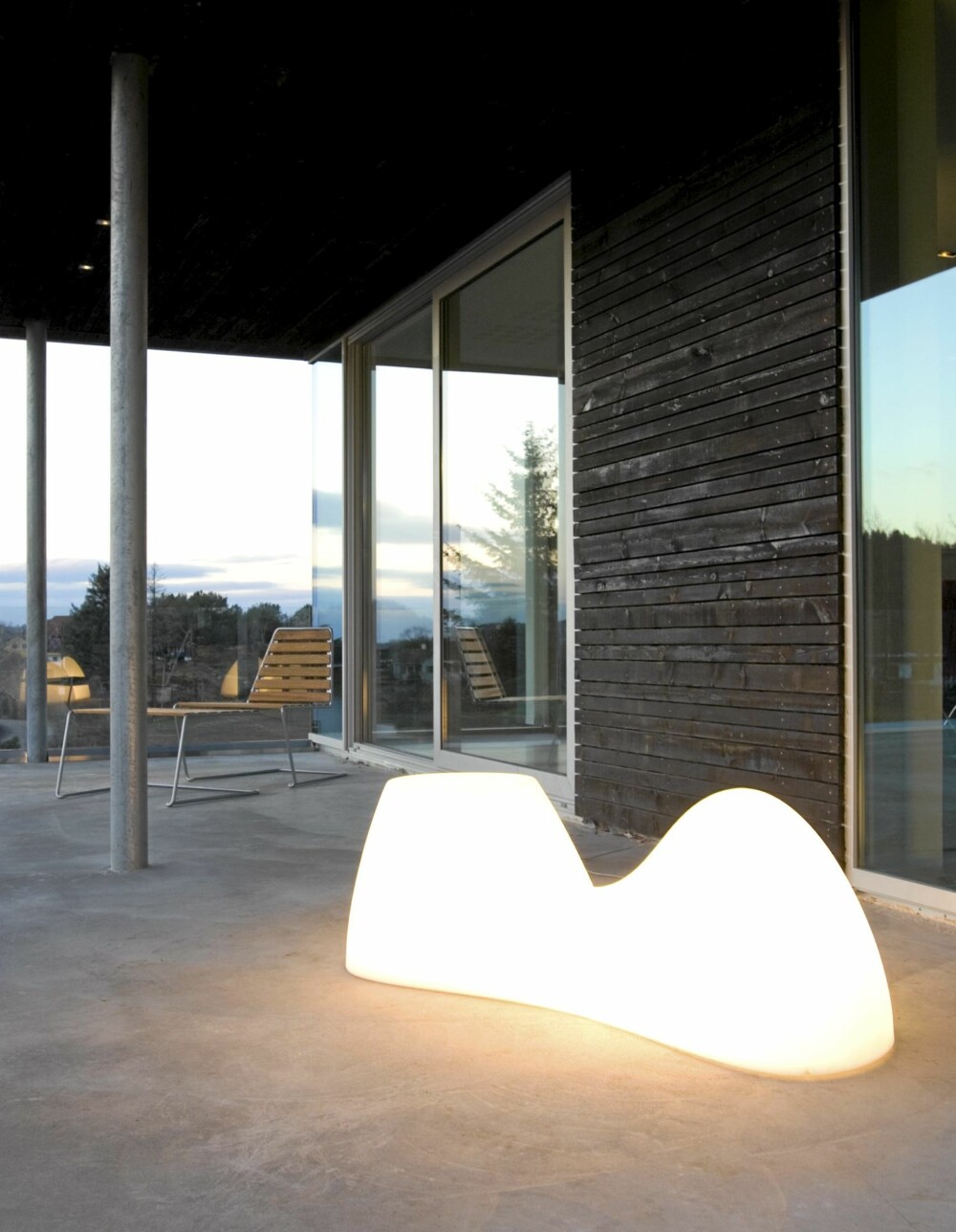 ENORM UTSIKT: Terrassen rett utenfor kjøkkenet hviler på toppen av åsryggen. Bred glass skyvedør i fasaden. Foscarini Blob utelampe. ENORM UTSIKT: Terrassen rett utenfor kjøkkenet hviler på toppen av åsryggen. Bred glass skyvedør i fasaden. Foscarini Blob utelampe.
