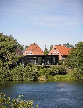 TIDLØS STIL: Det svarte trehuset ved sjøen i Odense ble bygget i slutten av 2007. Her omgis det av frodig vegetasjon til alle kanter. TIDLØS STIL: Det svarte trehuset ved sjøen i Odense ble bygget i slutten av 2007. Her omgis det av frodig vegetasjon til alle kanter.