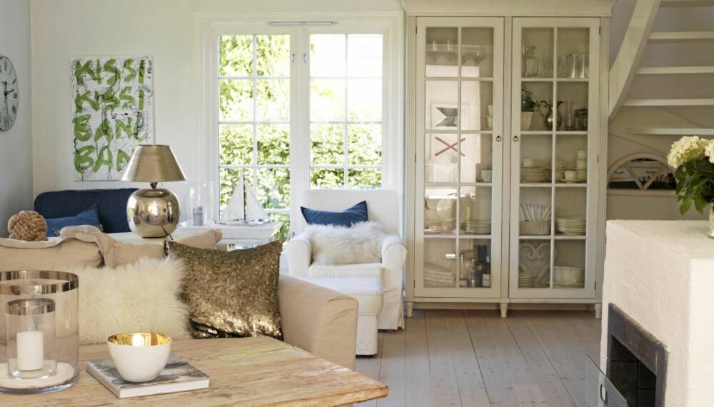 GULLDETALJER. Lampe og pute fra Bolina skaper gullglimt i stuen. Linsofaen er Rivera Maison fra Verket Interiør. Skapet rommer servise og andre bruksting. GULLDETALJER. Lampe og pute fra Bolina skaper gullglimt i stuen. Linsofaen er Rivera Maison fra Verket Interiør. Skapet rommer servise og andre bruksting.
