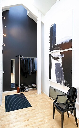 RETT INN. Ved inngangspartiet er det satt opp en enkel garderobe ved den svarte endeveggen. Bildet er "hjemmemalt", stol fra Philippe Starck. RETT INN. Ved inngangspartiet er det satt opp en enkel garderobe ved den svarte endeveggen. Bildet er "hjemmemalt", stol fra Philippe Starck.