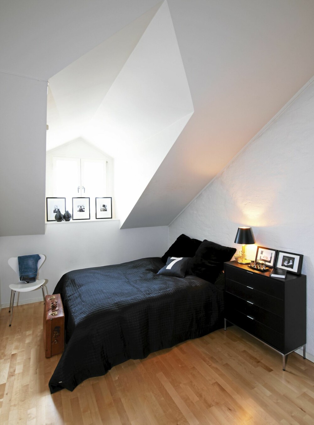 SVALT. I karmen og på kommoden fra Bolia har innrammede svart/hvitt-bilder fått plass. Murveggen gjør soverommet svalt. Lampen "Gun" er designet av Philippe Starck, fra Illums. SVALT. I karmen og på kommoden fra Bolia har innrammede svart/hvitt-bilder fått plass. Murveggen gjør soverommet svalt. Lampen "Gun" er designet av Philippe Starck, fra Illums.