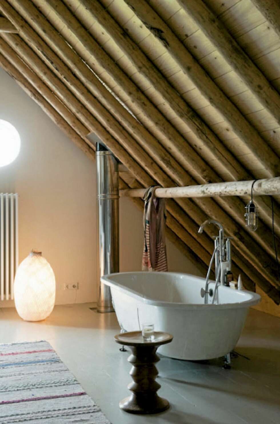 BADEKAR: På badet har beboerne et frittstående badekar under skråtaket. Dragerne fungerer til oppheng av både håndklær og belysning. Badet pleide å være lagringsrom for høy i gamle dager. BADEKAR: På badet har beboerne et frittstående badekar under skråtaket. Dragerne fungerer til oppheng av både håndklær og belysning. Badet pleide å være lagringsrom for høy i gamle dager.
