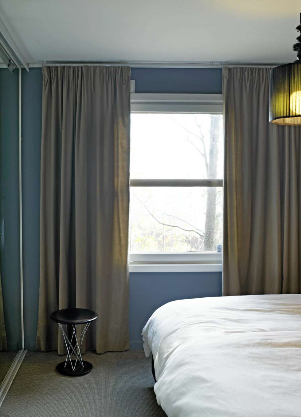 FORSTØRRER VINDUET: Gardinene dekker veggene på hver side av vinduet. Slik kan man forledes til å tro at vinduet egentlig er større enn det er. Gyngekrakken er fra Vitra. FORSTØRRER VINDUET: Gardinene dekker veggene på hver side av vinduet. Slik kan man forledes til å tro at vinduet egentlig er større enn det er. Gyngekrakken er fra Vitra.