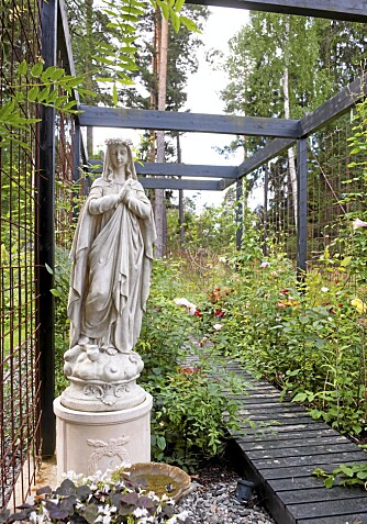 HAGEPYNT: I pergolaen står en skulptur til pynt blant roser og liljer som er i ferd med å avblomstre. Vår og sommer er det imidlertid frodig blomsterskog her. HAGEPYNT: I pergolaen står en skulptur til pynt blant roser og liljer som er i ferd med å avblomstre. Vår og sommer er det imidlertid frodig blomsterskog her.