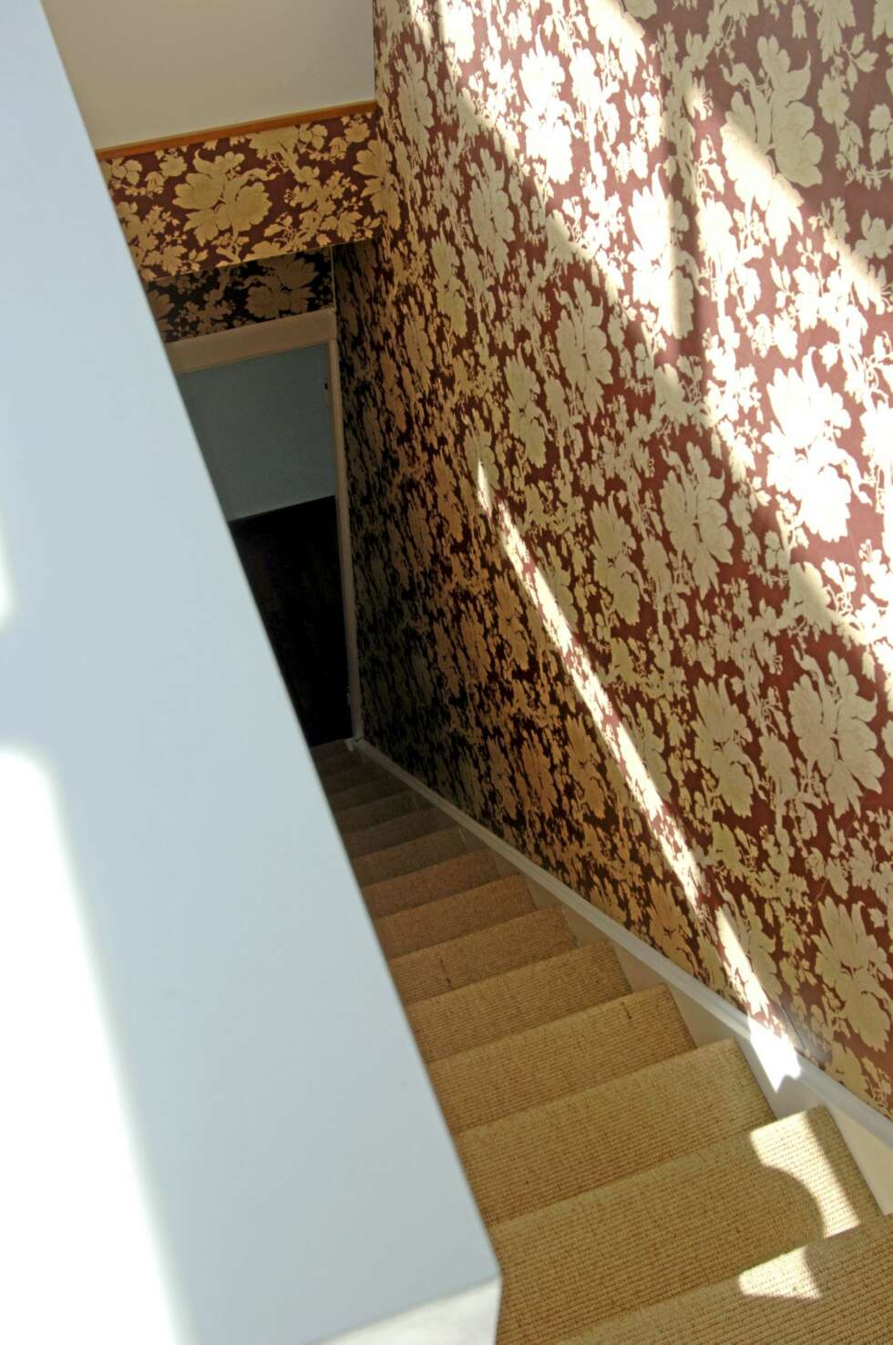 KONTASTER: Sprek trapp mot toppen. Det barokke tapet står i spenstig kontrast til alt det hvite i leiligheten. Sklisikre sisaltepper er gode å ha i slike bratte trapper. KONTASTER: Sprek trapp mot toppen. Det barokke tapet står i spenstig kontrast til alt det hvite i leiligheten. Sklisikre sisaltepper er gode å ha i slike bratte trapper.
