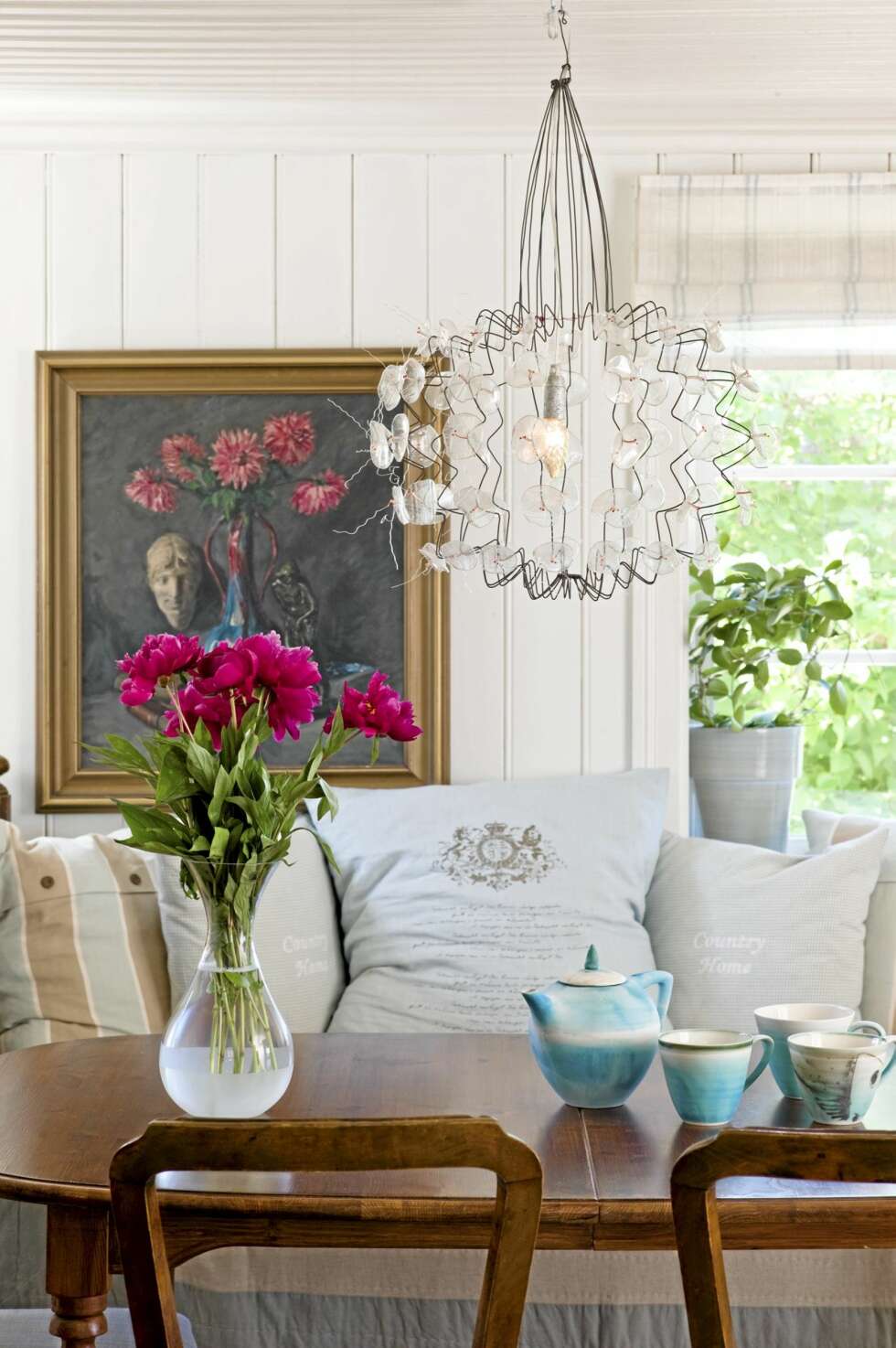 SMUKK SAMLING. Stillebenet på veggen er malt av Mariannes farfar. Lampen er laget av resirkulerte tåteflasker i plast, fra Galleri Soon. SMUKK SAMLING. Stillebenet på veggen er malt av Mariannes farfar. Lampen er laget av resirkulerte tåteflasker i plast, fra Galleri Soon.