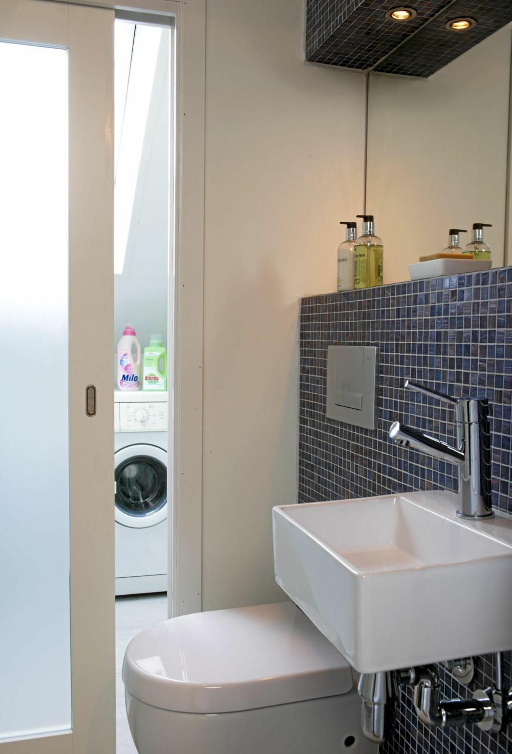 DELT: Det minste badet er delt med en skyvedør i frostet glass. På den måten kommer dagslyset inn i rommet, og vaskerommet er adskilt fra toalettet. DELT: Det minste badet er delt med en skyvedør i frostet glass. På den måten kommer dagslyset inn i rommet, og vaskerommet er adskilt fra toalettet.