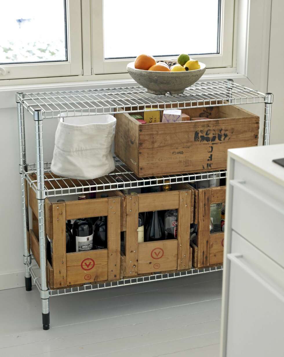 TØRT OG VÅTT: Stålstativet fra Ikea rommer blant annet gamle trekasser fra Vinmonopolet. Kassene brukes fremdeles til oppbevaring av vin og brennevin. TØRT OG VÅTT: Stålstativet fra Ikea rommer blant annet gamle trekasser fra Vinmonopolet. Kassene brukes fremdeles til oppbevaring av vin og brennevin.