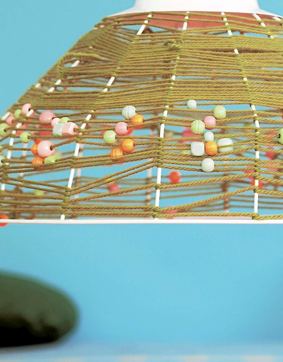 LAG KUL LAMPE: Du trenger et lampeskjelett av wire, ca. kr 530, House Doctor/Tina Sand, et olivengrønt garn og pastellfargede perler, fås hos Panduro Hobby. Start med å binde fast garnet øverst på lampen og surr det halvveis ned på stativet. Træ perler tett i tett på tråden og surr cirka en fjerdedel til. Træ nå færre perler på tråden og surr det siste stykket. Bind fast garnet i enden. LAG KUL LAMPE: Du trenger et lampeskjelett av wire, ca. kr 530, House Doctor/Tina Sand, et olivengrønt garn og pastellfargede perler, fås hos Panduro Hobby. Start med å binde fast garnet øverst på lampen og surr det halvveis ned på stativet. Træ perler tett i tett på tråden og surr cirka en fjerdedel til. Træ nå færre perler på tråden og surr det siste stykket. Bind fast garnet i enden.
