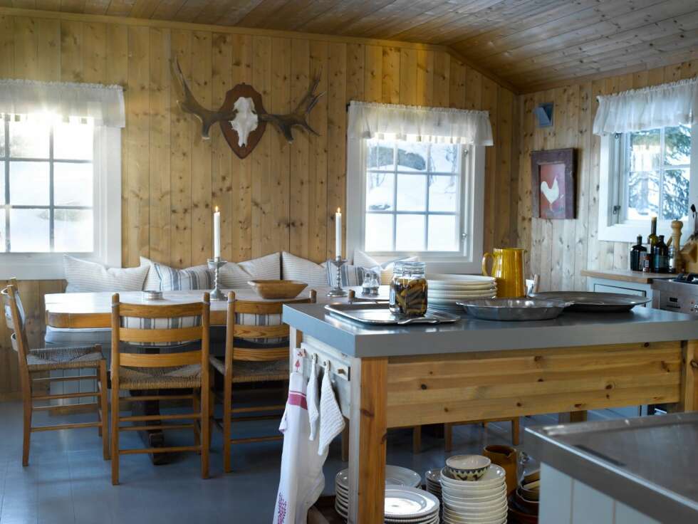 TRIVES BEST: Kjøkkenet er romslig, og er hyttas hjerte. Her står også en egen kjøkkenøy som benyttes som avlastningsbord. Rundt det avlange spisebordet er det plass til mange hyttegjester. TRIVES BEST: Kjøkkenet er romslig, og er hyttas hjerte. Her står også en egen kjøkkenøy som benyttes som avlastningsbord. Rundt det avlange spisebordet er det plass til mange hyttegjester.