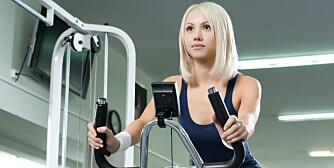 happy cutie athletic girl , execute exercise on exercise bicycle and smile, in sport-hall happy cutie athletic girl , execute exercise on exercise bicycle and smile, in sport-hall