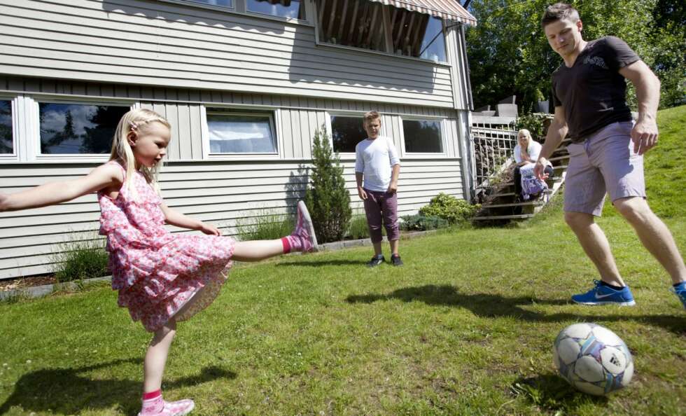 FOTBALL: Sarah sparker til ballen med full styrke på gressplenen utenfor huset. Storebror Sebastian og pappa Kjetil er ivrige medspillere. Mamma Torunn sitter i bakgrunnen og ser på. FOTBALL: Sarah sparker til ballen med full styrke på gressplenen utenfor huset. Storebror Sebastian og pappa Kjetil er ivrige medspillere. Mamma Torunn sitter i bakgrunnen og ser på.