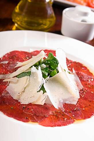 HELT RÅTT: Carpaccio er tynne, rå skiver av oksekjøtt overstrødd med parmesan og generøst krydret med salt og pepper. HELT RÅTT: Carpaccio er tynne, rå skiver av oksekjøtt overstrødd med parmesan og generøst krydret med salt og pepper.