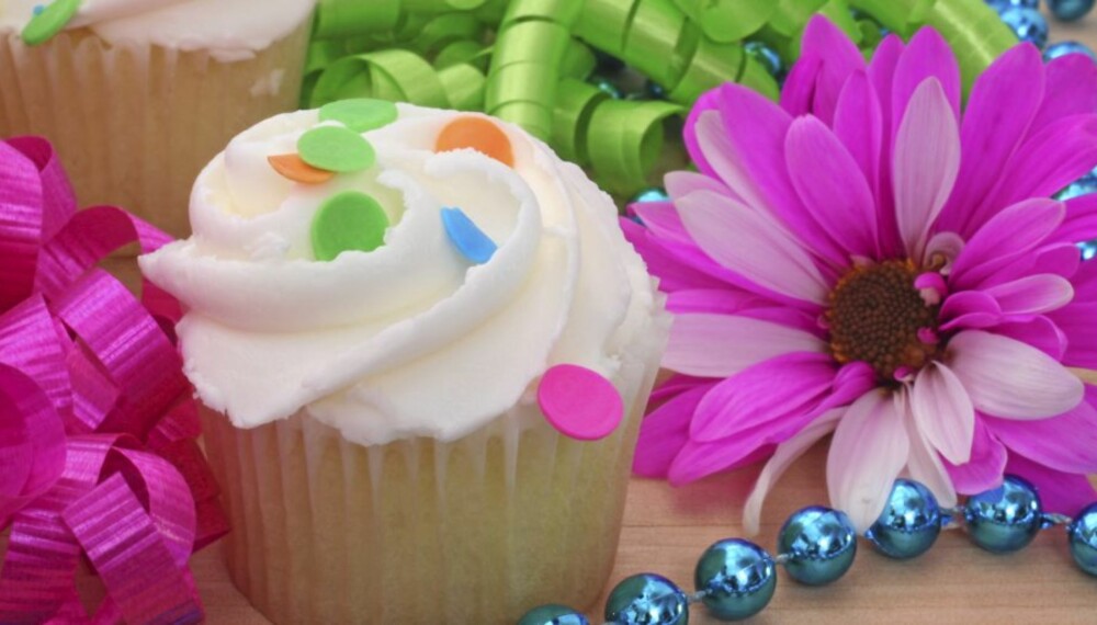 Cupcakes and Flower with Beads and Ribbon on Wooden Table Cupcakes and Flower with Beads and Ribbon on Wooden Table