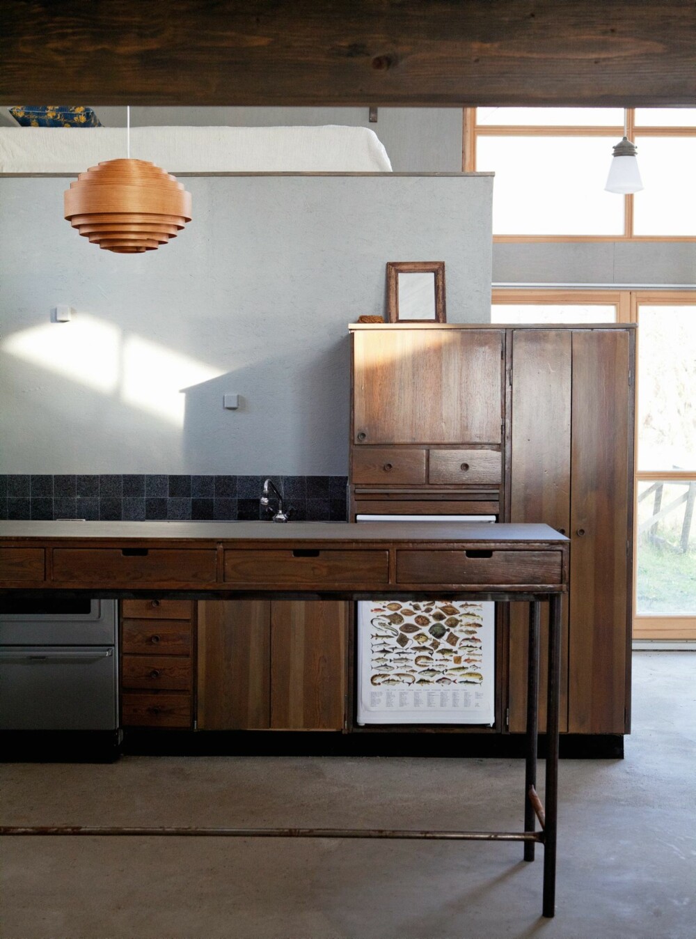 Fra 60-tallet: Kjøkkenet er gjenbruk av en innredning arkitekt og hytteeier Rolf tegnet på 1960-tallet, og som han hadde i sin første bolig. Nå har det flyttet inn i sjøboden, der det passer godt inn med sin grålaserte overflate og rake form. Over kjøkkenbenken er det granittfliser. Fra 60-tallet: Kjøkkenet er gjenbruk av en innredning arkitekt og hytteeier Rolf tegnet på 1960-tallet, og som han hadde i sin første bolig. Nå har det flyttet inn i sjøboden, der det passer godt inn med sin grålaserte overflate og rake form. Over kjøkkenbenken er det granittfliser.