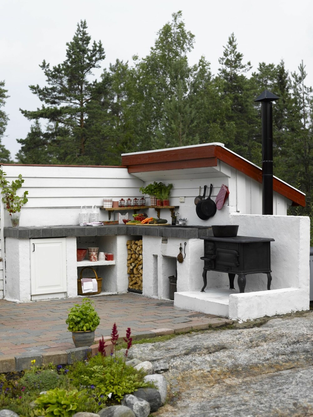 GOD PLASS: Har du plassen til det kan du mure opp et lite kjøkken. Dette utekjøkkenet står på et rødt mursteinsgulv, med en hvit og rød levegg. Her har beboerne både arbeidsbenk, ovn og spiseplass. GOD PLASS: Har du plassen til det kan du mure opp et lite kjøkken. Dette utekjøkkenet står på et rødt mursteinsgulv, med en hvit og rød levegg. Her har beboerne både arbeidsbenk, ovn og spiseplass.