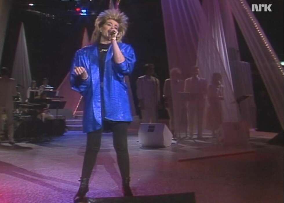 KATE GULDBRANDSEN (1987): Selv om Kate sjarmerte det norske folk med låta «Mitt liv», er det ikke den vi husker best fra Melodi Grand Prix-finalen i 1986.
Med den digre, blå skinnjakka og det høye håret var Kate et moteikon for norske damer. For de som ikke opplevde 80-tallet, kan det virke uforståelig at denne outfiten var svært trendy...
KATE GULDBRANDSEN (1987): Selv om Kate sjarmerte det norske folk med låta «Mitt liv», er det ikke den vi husker best fra Melodi Grand Prix-finalen i 1986.
Med den digre, blå skinnjakka og det høye håret var Kate et moteikon for norske damer. For de som ikke opplevde 80-tallet, kan det virke uforståelig at denne outfiten var svært trendy...