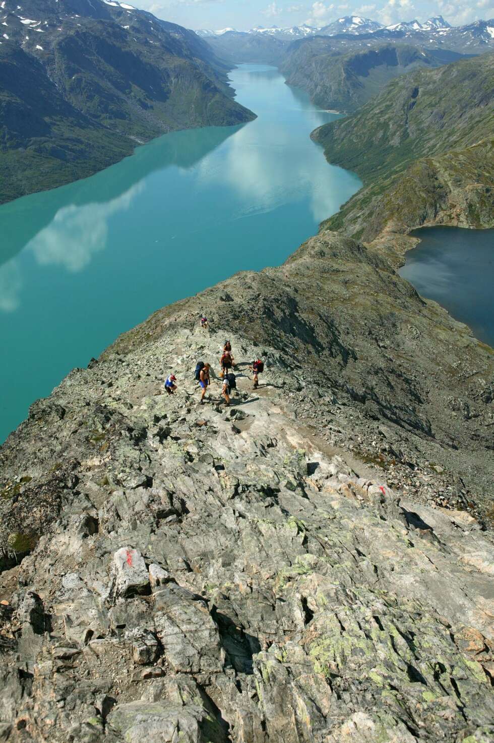 Besseggen Selv med et sterkt innslag av høydeskrekk der turkameratene måtte dra hetta over hodet mitt for at jeg skulle komme over den bratteste kneika, kan vi ikke annet enn å anbefale denne majestetiske turen langs denne fjellryggen i Vågå kommune. Besseggen ligger øst i Jotunheimen, mellom vannene Gjende og Bessvatnet. Turen er en av de mest populære i landet, og det var folksomt da Team MANN tok turen i fjor sommer. Besseggenvandring sto i år på det anerkjente magasinet National Geographics liste over «verdens mest spennende vandringer». Besseggen er 17 kilometer lang, og det høyeste punktet er på 1743 meter. Start gjerne turen med å ta båt til Memurubu, og så går du tilbake til Gjendesheim. De fleste kommer seg over på mellom fem og syv timer. Vi brukte seks timer med en del stopp langs veien. Utsikten skal jo nytes, den også. Foto: Morten Helgesen/VisitNorway.com Besseggen Selv med et sterkt innslag av høydeskrekk der turkameratene måtte dra hetta over hodet mitt for at jeg skulle komme over den bratteste kneika, kan vi ikke annet enn å anbefale denne majestetiske turen langs denne fjellryggen i Vågå kommune. Besseggen ligger øst i Jotunheimen, mellom vannene Gjende og Bessvatnet. Turen er en av de mest populære i landet, og det var folksomt da Team MANN tok turen i fjor sommer. Besseggenvandring sto i år på det anerkjente magasinet National Geographics liste over «verdens mest spennende vandringer». Besseggen er 17 kilometer lang, og det høyeste punktet er på 1743 meter. Start gjerne turen med å ta båt til Memurubu, og så går du tilbake til Gjendesheim. De fleste kommer seg over på mellom fem og syv timer. Vi brukte seks timer med en del stopp langs veien. Utsikten skal jo nytes, den også. Foto: Morten Helgesen/VisitNorway.com