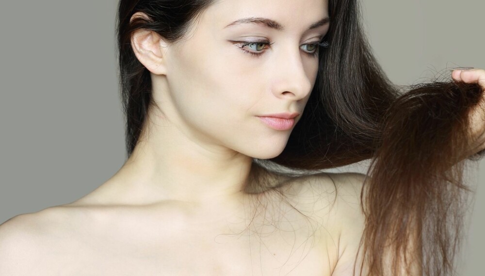 Care of damaged woman hair. Closeup portrait of beautiful woman holding hand long hair and thinking unhappy Care of damaged woman hair. Closeup portrait of beautiful woman holding hand long hair and thinking unhappy