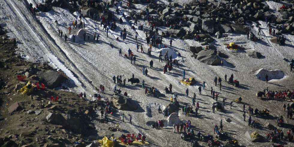 Weekendturistene leker og har det moro i snøen i høyfjellet ved Rohtang Pass etter mange, lange timer i kø opp fjellsiden. Weekendturistene leker og har det moro i snøen i høyfjellet ved Rohtang Pass etter mange, lange timer i kø opp fjellsiden.