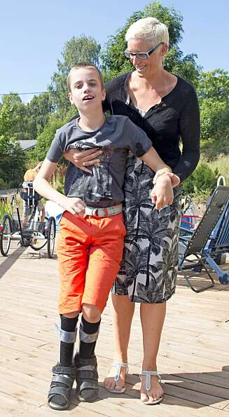 HJELPETRENGENDE: Ved hjelp av spesiallagde skinner kan Lukas (12) gå litt med støtte fra mamma Evie. Håpet er at han skal kunne gå fra bilen til huset på egen hånd. HJELPETRENGENDE: Ved hjelp av spesiallagde skinner kan Lukas (12) gå litt med støtte fra mamma Evie. Håpet er at han skal kunne gå fra bilen til huset på egen hånd.