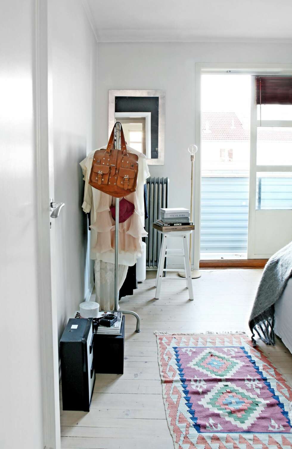 EN KUL MIKS: Soverommet har utgang til en balkong. Klesstativet er fra Granit, og kelimteppet fra et loppemarked. FOTO: Mint Agency EN KUL MIKS: Soverommet har utgang til en balkong. Klesstativet er fra Granit, og kelimteppet fra et loppemarked. FOTO: Mint Agency