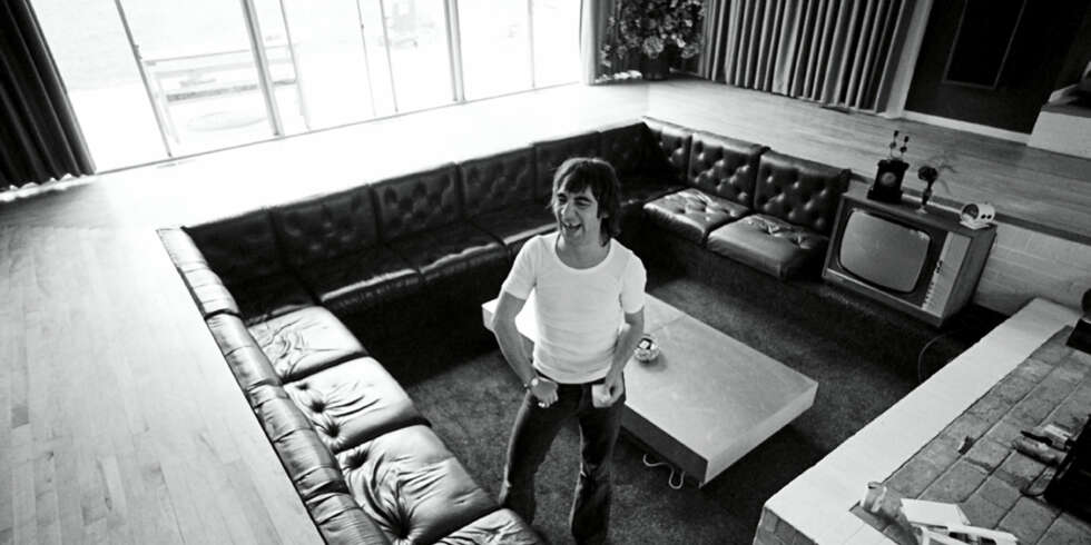 NEDSENKBART: Stua lå i den midterste pyramiden, med en stor sofa nedsenket, innrammet av treverk. I senter av hele huset var ildstedet. Her er Keith alene, noe som var uvanlig skal man tro de mange historiene om ham. I dokumentarfilmen «The Real Keith Moon» fortelles det av venner som kom på besøk at det gjerne lå folk og sov i stua nesten bestandig. NEDSENKBART: Stua lå i den midterste pyramiden, med en stor sofa nedsenket, innrammet av treverk. I senter av hele huset var ildstedet. Her er Keith alene, noe som var uvanlig skal man tro de mange historiene om ham. I dokumentarfilmen «The Real Keith Moon» fortelles det av venner som kom på besøk at det gjerne lå folk og sov i stua nesten bestandig.