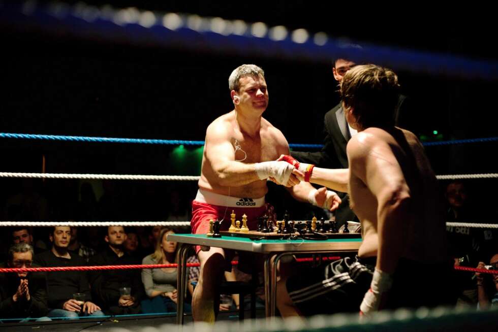 Patrick Teehan (rød shorts) har nettopp tapt for Hubert Van Melick på sjakk matt i tredje runde, og spillerne takker for kampen. Patrick Teehan (rød shorts) har nettopp tapt for Hubert Van Melick på sjakk matt i tredje runde, og spillerne takker for kampen.