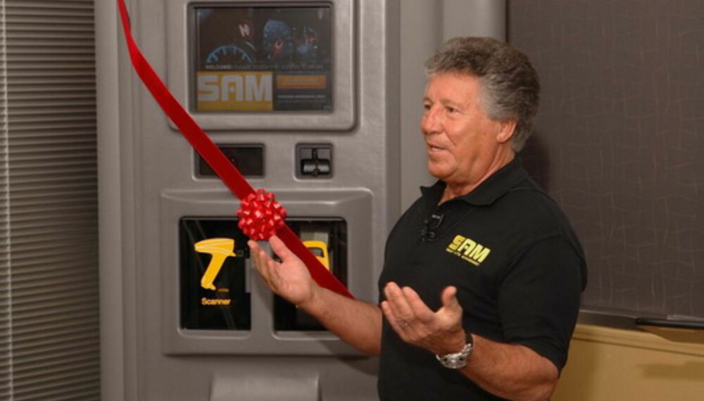 Mario Andretti viser fram en SAM-kiosk. Mario Andretti viser fram en SAM-kiosk.