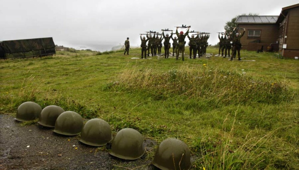 Dag to på kystfortet. Rekken av hjelmer til dem som har gitt opp vokser, mens marinejegeraspirantene driver våpendrill i regnet. Foto: Håkon Bonafede Dag to på kystfortet. Rekken av hjelmer til dem som har gitt opp vokser, mens marinejegeraspirantene driver våpendrill i regnet. Foto: Håkon Bonafede