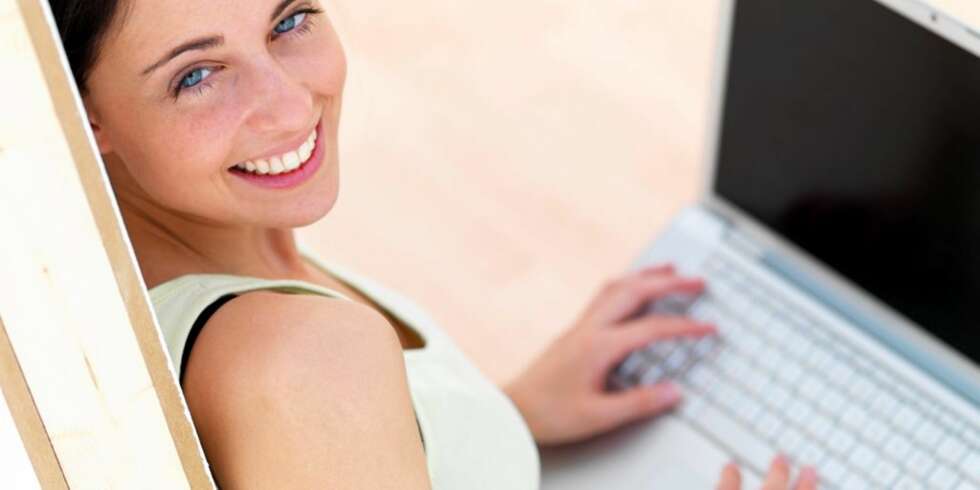 Closeup portrait of a happy young woman using laptop Closeup portrait of a happy young woman using laptop