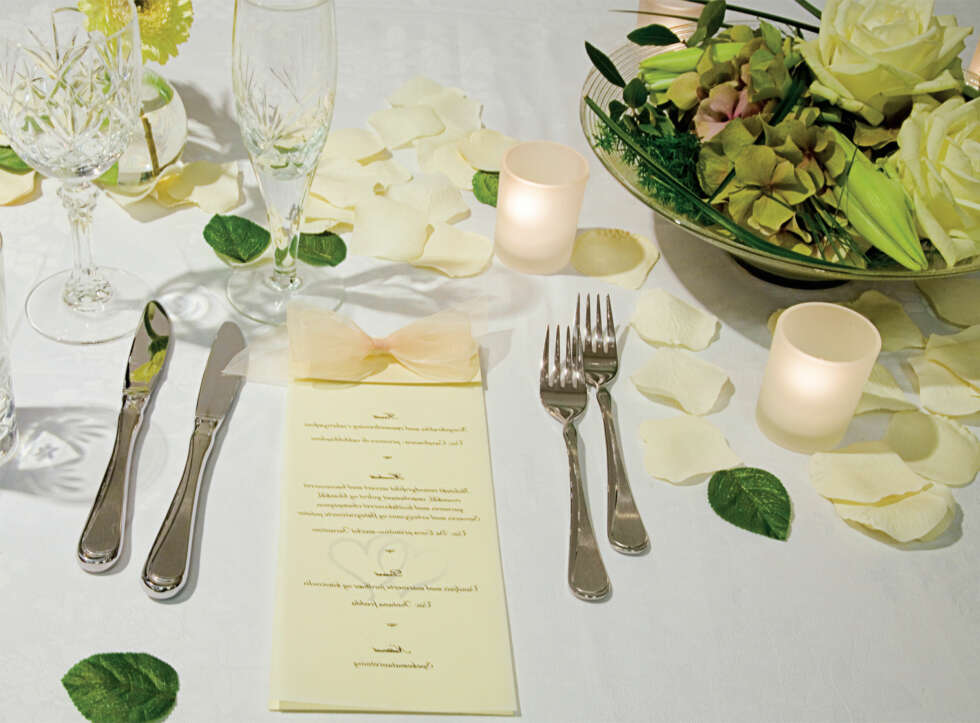 KLASSISK: Roseblader, kubbelys, telys, perlerekker,
offwhite gaveesker, servietter i offwhite med gulltrykk av brydeparets navn. I denne blomsterdekorasjonen fra Kreativ Flora er det brukt blant annet roser, hortensia og olivenblader. Olivenblader kan også benyttes til å strø på bordet som en dekoreffekt. Elfenben og gull passer perfekt til klassiske bryllupslokaler, og setter alltid rammen for et tidløst bryllup. KLASSISK: Roseblader, kubbelys, telys, perlerekker,
offwhite gaveesker, servietter i offwhite med gulltrykk av brydeparets navn. I denne blomsterdekorasjonen fra Kreativ Flora er det brukt blant annet roser, hortensia og olivenblader. Olivenblader kan også benyttes til å strø på bordet som en dekoreffekt. Elfenben og gull passer perfekt til klassiske bryllupslokaler, og setter alltid rammen for et tidløst bryllup.