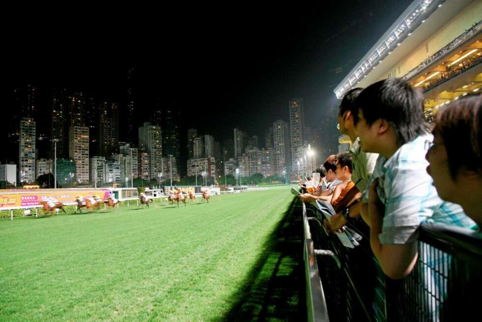 VEDDELØP: På Happy Valley er det stappfullt av mennesker når det hver uke arrangeres hesteveddeløp. Merk høyhusene i bakgrunnen. VEDDELØP: På Happy Valley er det stappfullt av mennesker når det hver uke arrangeres hesteveddeløp. Merk høyhusene i bakgrunnen.