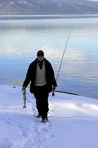 VINTER-FANSGT: Denne fiskeren har fått en pen snø-ørret. VINTER-FANSGT: Denne fiskeren har fått en pen snø-ørret.