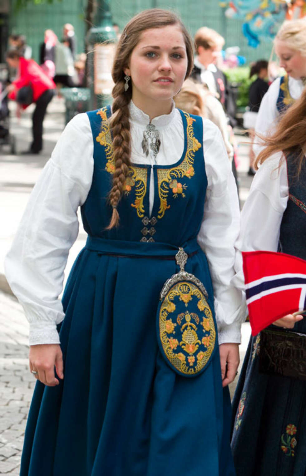 BUNAD: Hva slags bunad er dette?: romeriksbunad for kvinne
Hvem ser vi på bildet? : en kvinne i bunad
Hvor er bildet tatt, og i hvilken situasjon?: utendørs på 17.mai BUNAD: Hva slags bunad er dette?: romeriksbunad for kvinne
Hvem ser vi på bildet? : en kvinne i bunad
Hvor er bildet tatt, og i hvilken situasjon?: utendørs på 17.mai