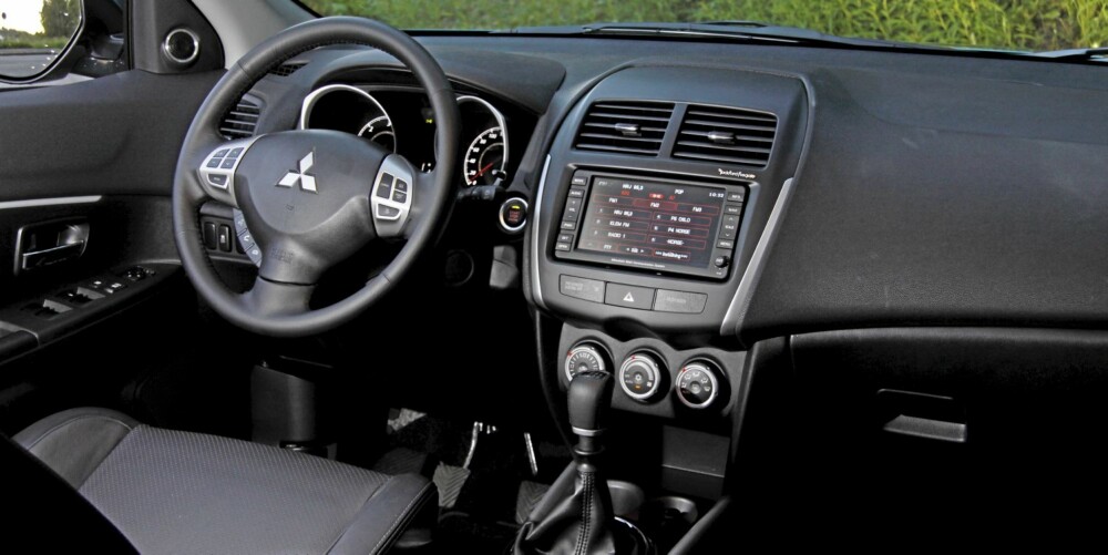 OVERRASKELSEN: Endelig har Mitsubishi dybdejustering av rattet i en av sine modeller. Interiøret er ryddig men ikke veldig eksklusivt. OVERRASKELSEN: Endelig har Mitsubishi dybdejustering av rattet i en av sine modeller. Interiøret er ryddig men ikke veldig eksklusivt.