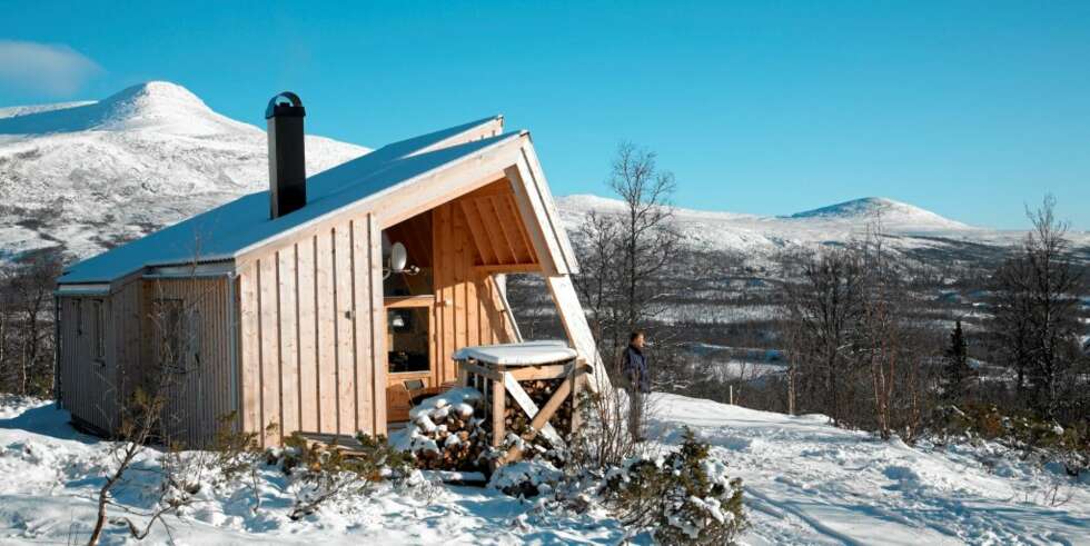 INSPIRERT AV OMGIVELSENE: Et massivt fjellkjede omslutter den moderne hytta med elementene som lener seg mot hverandre. INSPIRERT AV OMGIVELSENE: Et massivt fjellkjede omslutter den moderne hytta med elementene som lener seg mot hverandre.