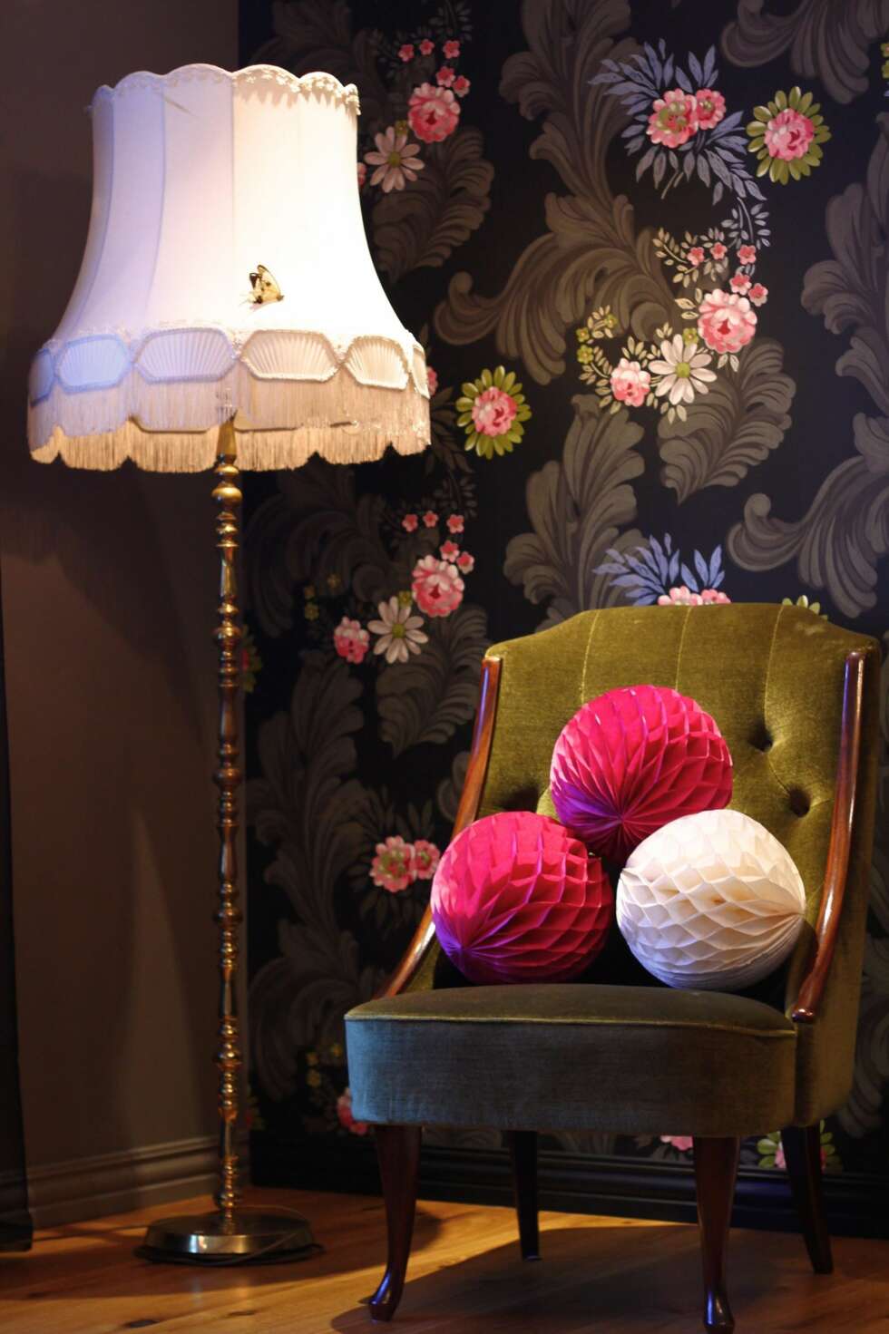 En sommerfugl og rosa pom poms pynter opp på en stol og en lampe i det ene hjørnet av stuen. En sommerfugl og rosa pom poms pynter opp på en stol og en lampe i det ene hjørnet av stuen.