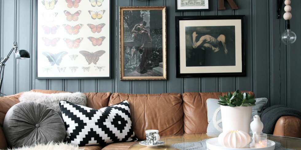 Bak sofaen har Lene laget en bildevegg med forskjellige rammer og motiver. Bak sofaen har Lene laget en bildevegg med forskjellige rammer og motiver.