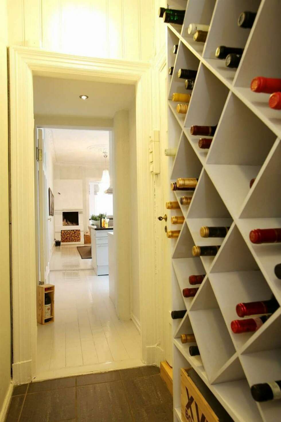 Plassen ved bakinngangen er utnyttet med hyller til oppbevaring av vin. Plassen ved bakinngangen er utnyttet med hyller til oppbevaring av vin.