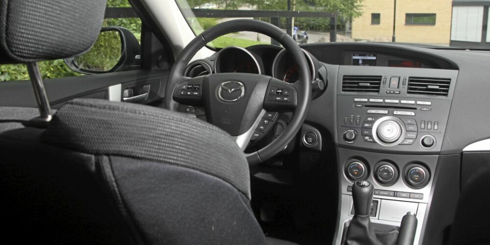 SPORTY: Interiøret i Mazda 3 er småsporty, men preges av en del plast. Særlig påkostet føles den ikke. Sportssetene er imidlertid å anbefale! SPORTY: Interiøret i Mazda 3 er småsporty, men preges av en del plast. Særlig påkostet føles den ikke. Sportssetene er imidlertid å anbefale!