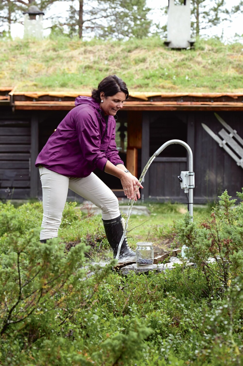 FRISKT VANN: Sidsel Espe henter vann fra vannposten på tunet, som er fra Vasspumper på Biri. Vannet bæres inn til kjøkkenet og en varmtvannsbereder i badehuset. FRISKT VANN: Sidsel Espe henter vann fra vannposten på tunet, som er fra Vasspumper på Biri. Vannet bæres inn til kjøkkenet og en varmtvannsbereder i badehuset.