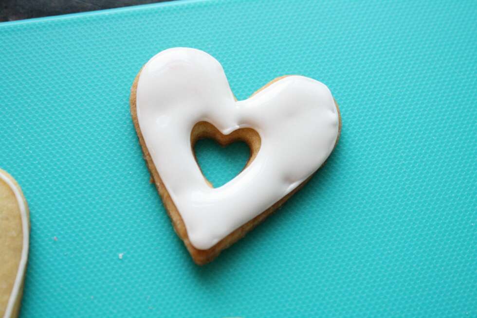 HJERTECOOKIES: Fyll rammen med den flytende glasuren. HJERTECOOKIES: Fyll rammen med den flytende glasuren.