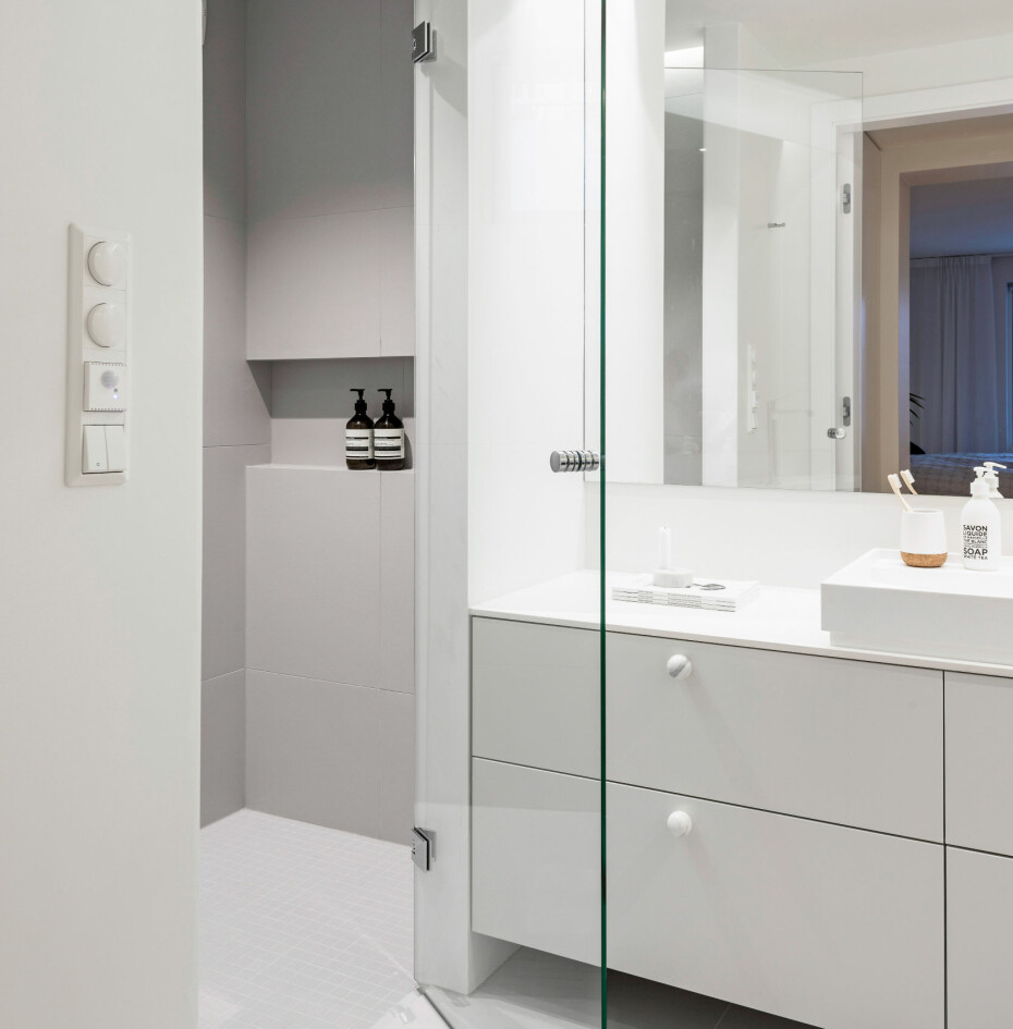 Badet er langt og smalt. Ved å bygge et raust dusjrom langs hele badets venstre kortende minskes det avlange preget. Badet er langt og smalt. Ved å bygge et raust dusjrom langs hele badets venstre kortende minskes det avlange preget.