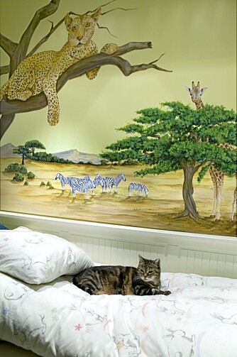 SLEKTSKAP. Barnerommet har fått morsomme bilder malt rett på veggen. Monica Tollnes er illustratør. Katten Else føler seg hjemme under treet med leoparden.