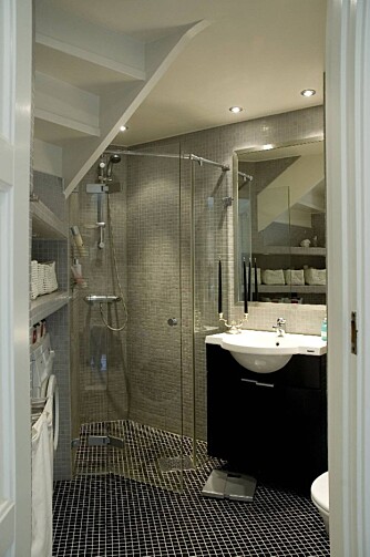 Se på dette flotte badet! Svarte og grå mosaikkfliser på badet er rålekkert.