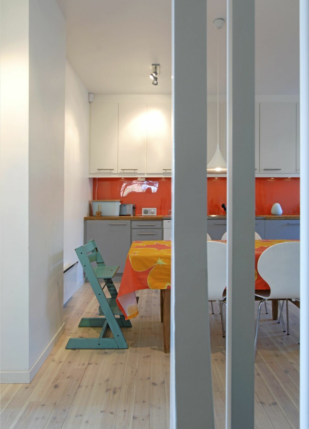 FRA VEGG TIL VEGG: Pleksiplaten over kjøkkenbenken går fra vegg til vegg i kjøkkenet. Den gilde oransjefargen bak er malt rett på bakveggen.
