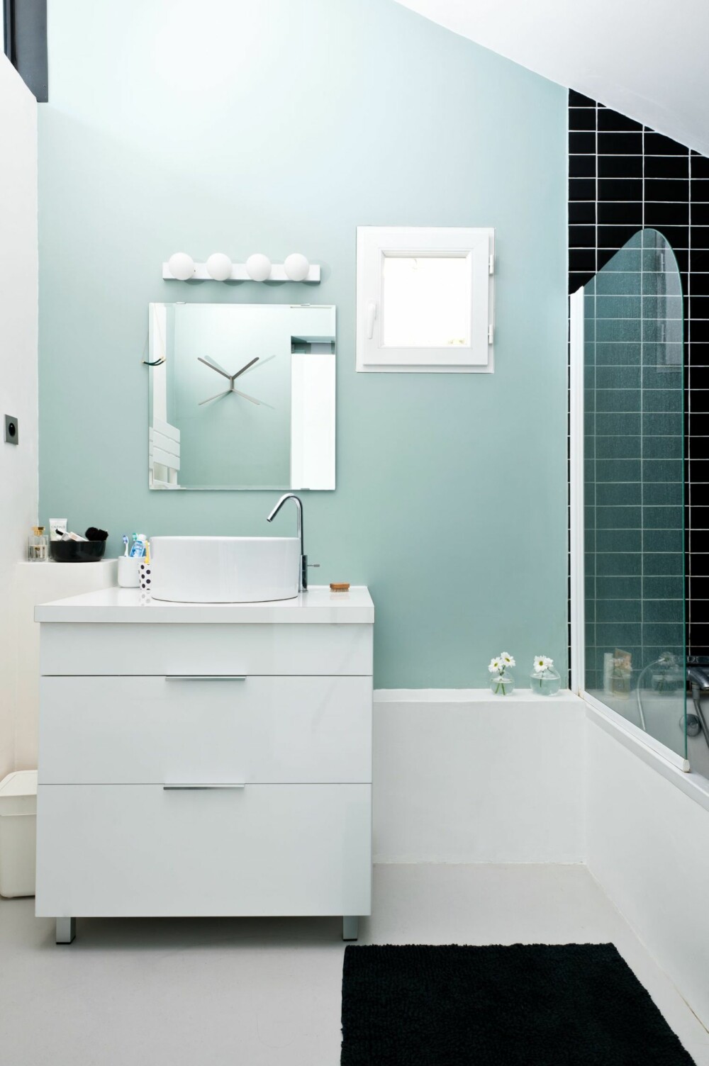 PÅ BADET: Badet er lite, men stilig med svarte fliser og himmelblå vegg. Baderomsinnredning fra Ikea og Leroy Merlin.