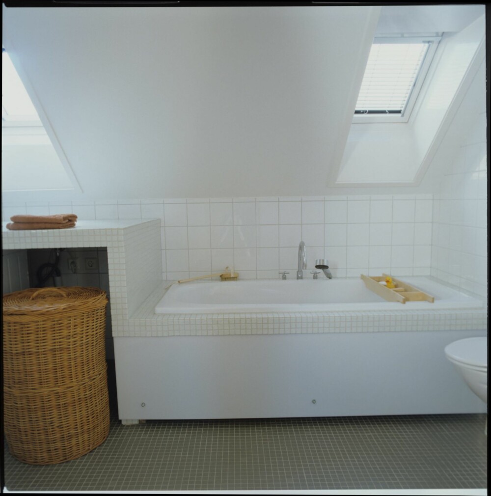 OPPUSSET MED STIL: Badet på loftet preges av de bratte takene og alle overlysvinduene. Badekarfronten er i akrylplast.