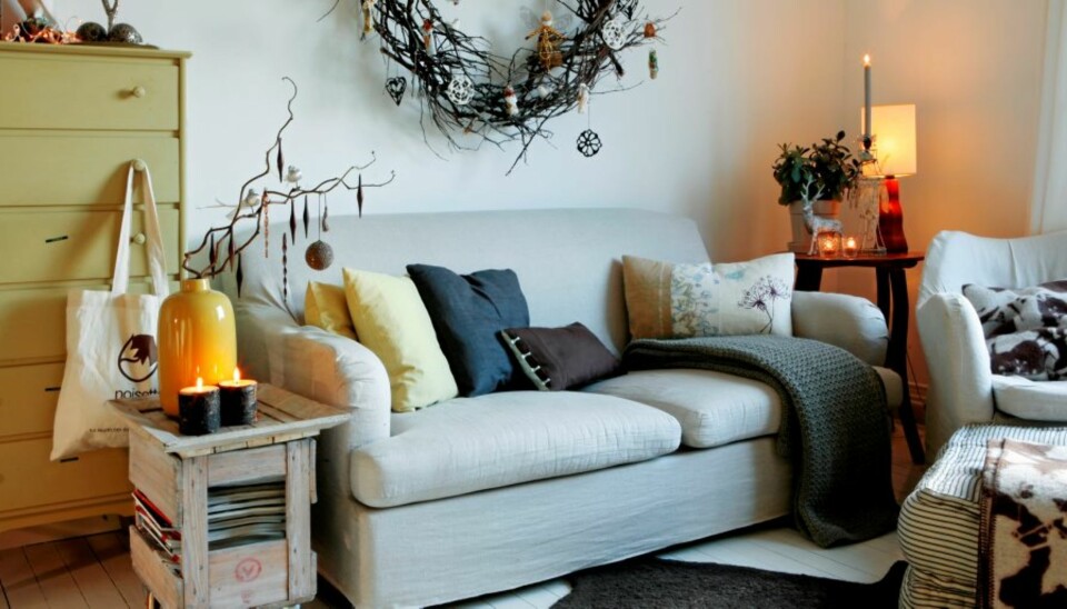 Bente har selv sydd trekket til Ikea-sofaen. Den lekre julekransen på veggen har hun også lagd. Kvistene til den store kransen på veggen fant hun på en hyttetur på Hvaler. Ved å henge forskjellige typer juletrepynt på, går hun julen i møte med et alternativt juletre. Det er perfekt når gulvplassen ikke er så stor. Det kule, lille bordet til venstre har Bente lagd av en gammel vinkasse, som hun har lasert. I tillegg har det fått hjul fra Ikea. På toppen er det festet et brett - det passet akkurat.